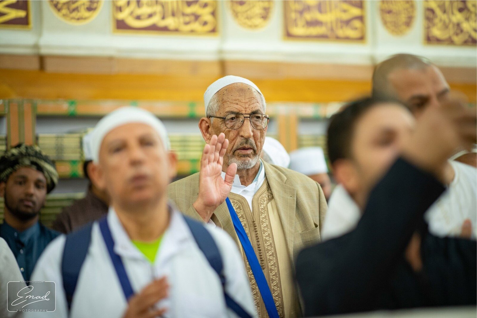 An elderly pilgrim making dua, hand raised