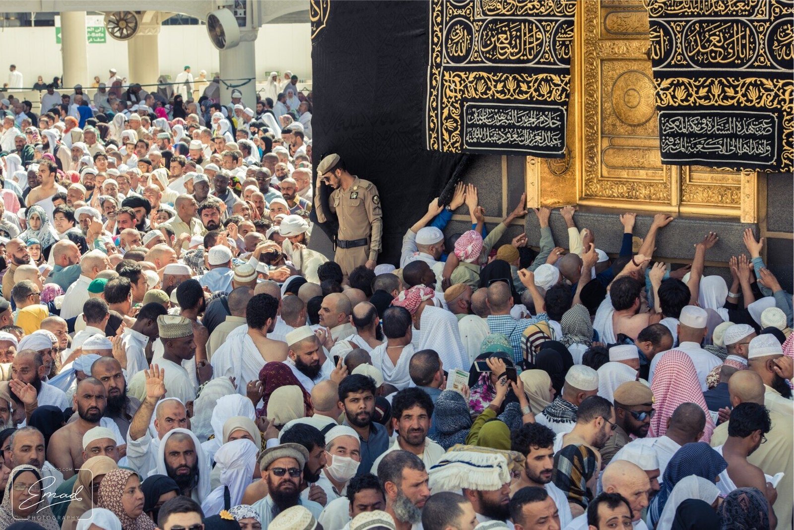 Pilgrims reaching toward the Black Stone at the corner of the Ka'bah