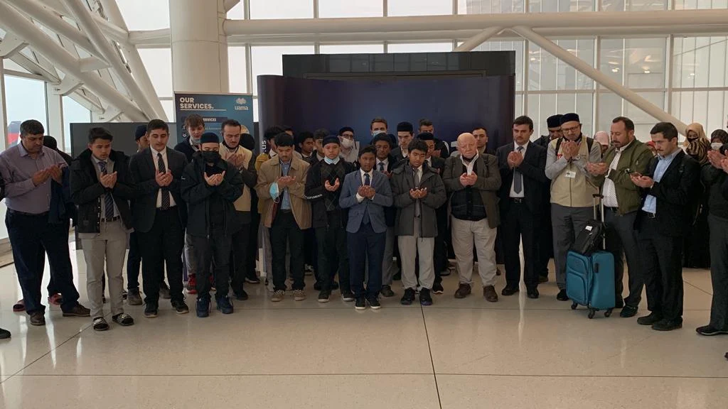 A Hisar Tour group making du'a together at the airport before departing for Umrah