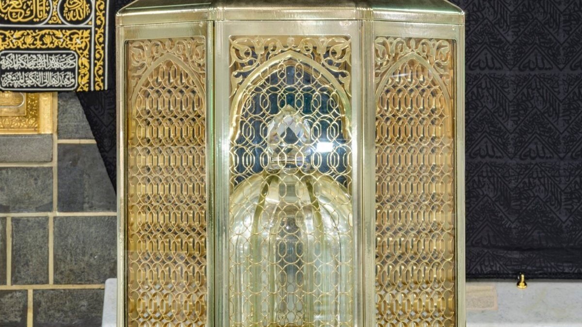 Maqam Ibrahim in its golden glass enclosure in front of the Kaaba at night