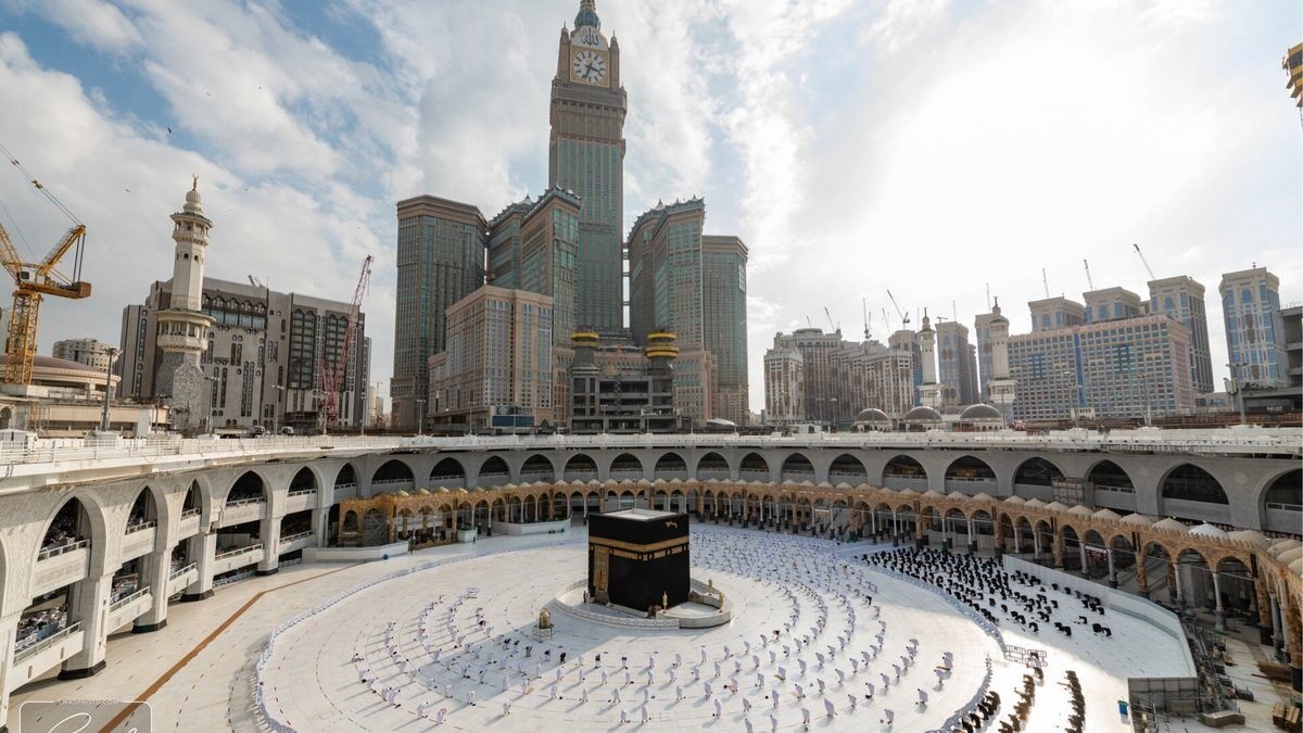 The Kaaba and the mataf seen from an upper level of Masjid al-Haram with the clock tower behind