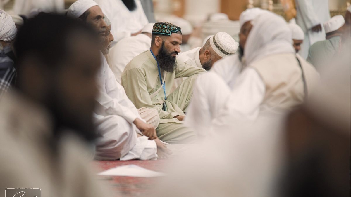 A Hisar Tour group of pilgrims walking together toward Masjid al-Haram with their imam